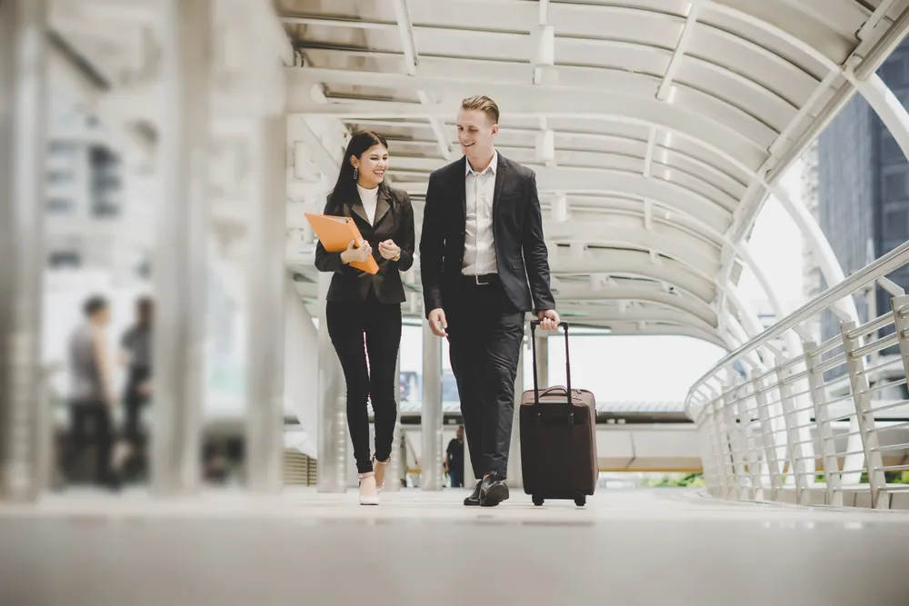 Patient escorted with his luggage through a covered walkway